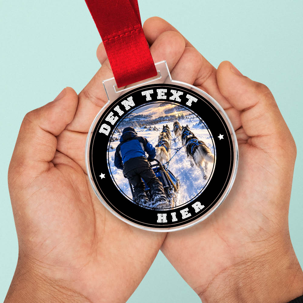Signature Medaille Hundeschlittenrennen in Händen als Größenvergleich